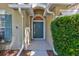 Close-up of the home's front door, framed by greenery and an arched entryway at 1518 Rolling Meadow Dr, Valrico, FL 33594