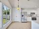Well-lit kitchen featuring white cabinets, stainless appliances, and a large window at 1518 Rolling Meadow Dr, Valrico, FL 33594