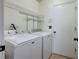 Practical laundry room with washer, dryer, and shelving for storage solutions at 1518 Rolling Meadow Dr, Valrico, FL 33594