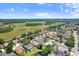 This aerial captures a home with a screened pool, situated among other residences, with a sprawling green space in the background at 16118 Lytham Dr, Odessa, FL 33556