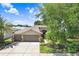 Charming home featuring a three-car garage, well-maintained landscaping, and a concrete driveway at 16118 Lytham Dr, Odessa, FL 33556