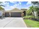 Charming home featuring a three-car garage, well-maintained landscaping, and a concrete driveway at 16118 Lytham Dr, Odessa, FL 33556