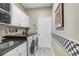 Functional laundry room with ample storage, countertop space, a sink, and appliances at 16118 Lytham Dr, Odessa, FL 33556