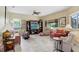 Spacious living room with tile flooring, a ceiling fan, and a large entertainment center at 16118 Lytham Dr, Odessa, FL 33556