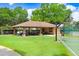Inviting outdoor picnic area with a covered shelter, picnic tables, and lush green lawn for gatherings at 16118 Lytham Dr, Odessa, FL 33556