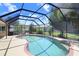 Enclosed pool area featuring a screened enclosure, and a well-maintained pool with a paver deck at 16118 Lytham Dr, Odessa, FL 33556