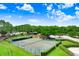 Scenic aerial view of outdoor tennis courts and nearby recreational facilities, surrounded by mature trees and green spaces at 16118 Lytham Dr, Odessa, FL 33556