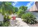A charming brick patio with Adirondack chairs and lush tropical landscaping, creating a serene outdoor retreat at 16118 Lytham Dr, Odessa, FL 33556