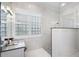 This bathroom has stone counters, a window with shutters, a stand-up shower, and a crystal light fixture at 16629 Sedona De Avila, Tampa, FL 33613