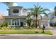 Charming two-story home featuring a well-manicured lawn, tropical landscaping, and a gray stucco exterior at 16629 Sedona De Avila, Tampa, FL 33613