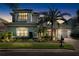 Stunning two-story home with manicured landscaping, warm exterior lighting, and inviting curb appeal at twilight at 16629 Sedona De Avila, Tampa, FL 33613