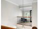 View of a hallway with an armchair, tile flooring, and a black iron railing at 16629 Sedona De Avila, Tampa, FL 33613