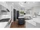 Bright kitchen featuring white cabinetry, dark island, stainless appliances, and modern fixtures at 16629 Sedona De Avila, Tampa, FL 33613