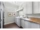 Bright laundry room with a granite countertop, white cabinets, a sink, and modern appliances at 16629 Sedona De Avila, Tampa, FL 33613