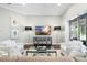 Comfortable living room featuring neutral decor, media cabinet and direct access to outdoor patio at 16629 Sedona De Avila, Tampa, FL 33613