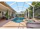 Beautiful screened-in pool and spa area with a brick patio, lush foliage, and a covered lanai at 16629 Sedona De Avila, Tampa, FL 33613