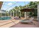Inviting screened pool with brick-paved patio offers sun loungers and privacy in a tropical backyard setting at 16629 Sedona De Avila, Tampa, FL 33613