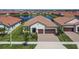 Stunning aerial view of a home near the pond, featuring a tile roof, and lush landscaping at 17583 Holly Well Ave, Wimauma, FL 33598