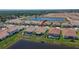 An aerial view of the property's backyard with a pool, overlooking a serene pond at 17583 Holly Well Ave, Wimauma, FL 33598