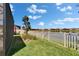 Landscaped backyard with a serene lake view, enclosed by a white picket fence for privacy at 17583 Holly Well Ave, Wimauma, FL 33598