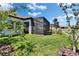 The well-maintained backyard includes a screened lanai and lush greenery for a peaceful retreat at 17583 Holly Well Ave, Wimauma, FL 33598