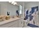 Bright bathroom featuring a modern vanity, sleek faucet, geometric shower curtain and natural lighting at 17583 Holly Well Ave, Wimauma, FL 33598
