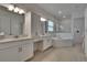 Bright bathroom featuring dual sinks, corner tub, glass shower, and modern fixtures at 17583 Holly Well Ave, Wimauma, FL 33598