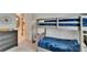 Bright bedroom with a cozy bunk bed and stylish gray dresser with unique decor at 17583 Holly Well Ave, Wimauma, FL 33598