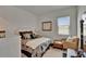Relaxing bedroom features a window, a comfortable chair, and a well-decorated bed at 17583 Holly Well Ave, Wimauma, FL 33598