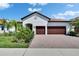 Beautiful home with a two-car garage, stone driveway and lush landscaping at 17583 Holly Well Ave, Wimauma, FL 33598