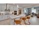 Modern kitchen features an island with seating, stainless steel appliances, and a decorative backsplash at 17583 Holly Well Ave, Wimauma, FL 33598