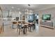 Open kitchen and dining area with island seating, modern lighting, and stainless steel appliances at 17583 Holly Well Ave, Wimauma, FL 33598