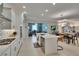 A bright kitchen features stainless steel appliances, an island with seating, and views into the living space at 17583 Holly Well Ave, Wimauma, FL 33598