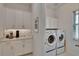 Convenient laundry room with washer, dryer, and built in cabinets at 17583 Holly Well Ave, Wimauma, FL 33598