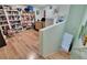 Well-lit home office area with hardwood floors, built-in bookshelves, and ample storage at 17583 Holly Well Ave, Wimauma, FL 33598