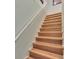 Interior staircase featuring wood steps, white railing, and neutral-colored wall at 17583 Holly Well Ave, Wimauma, FL 33598