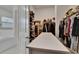 Spacious walk-in closet with storage shelves, clothing racks, and center island at 17583 Holly Well Ave, Wimauma, FL 33598
