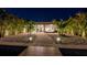 Backyard at night featuring a covered patio, lush landscaping, walkway, and illuminated fire pit at 17730 Long Point Dr, Redington Shores, FL 33708