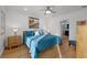 Well-lit bedroom features light wood floors, a ceiling fan, and an ensuite bathroom at 17730 Long Point Dr, Redington Shores, FL 33708