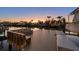 Waterfront dock with bench seating and boat slip at sunset at 17730 Long Point Dr, Redington Shores, FL 33708