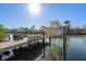 Dock with boat lift on a sunny day with tropical foliage at 17730 Long Point Dr, Redington Shores, FL 33708