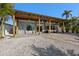 The exterior of the home features a covered patio, tropical landscaping, and modern design at 17730 Long Point Dr, Redington Shores, FL 33708
