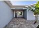 Covered front entry with paver steps and a freshly painted front door at 17730 Long Point Dr, Redington Shores, FL 33708