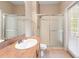 Bathroom featuring a glass-door shower, large mirror, and a sink with a tiled countertop at 18310 Bankston Pl, Tampa, FL 33647