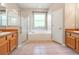 Bathroom featuring dual sinks, a glass shower, a soaking tub under a window, and tiled floors at 18310 Bankston Pl, Tampa, FL 33647