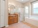 Bathroom showcasing a sink, mirror, shower, and bathtub with a glass door, all with tiled floors at 18310 Bankston Pl, Tampa, FL 33647