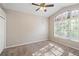 Neutral bedroom featuring carpeted floors, a ceiling fan, and a large arched window providing natural light at 18310 Bankston Pl, Tampa, FL 33647