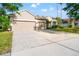 Street view showcasing the home's facade, large driveway, three-car garage, and landscaped front yard at 18310 Bankston Pl, Tampa, FL 33647