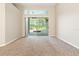 Living room with neutral walls and flooring; a sliding glass door leads to an outdoor patio with pool at 18310 Bankston Pl, Tampa, FL 33647