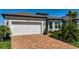 Inviting home with a brick driveway, two-car garage, manicured landscaping, and stone accents at 19442 Sea Glass Cir, Land O Lakes, FL 34638